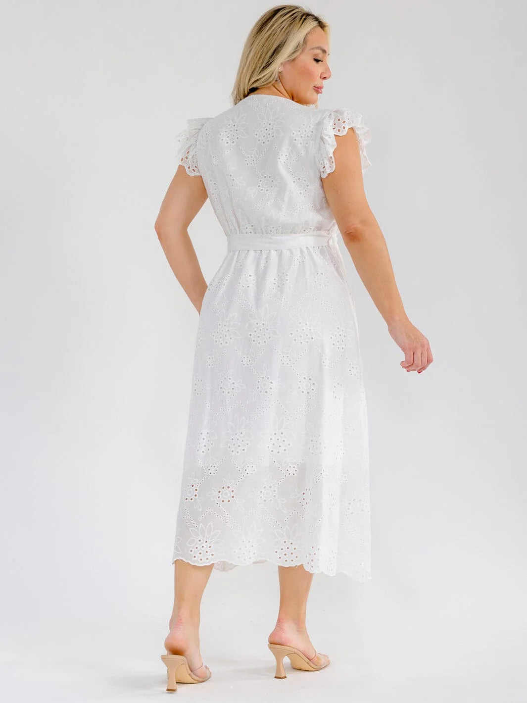 Back view of a woman wearing a Plus Size Ruffle Sleeve Surplice Elastic Waist Eyelet Maxi Dress in white.